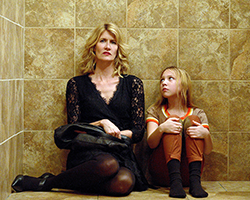 The Tale - woman (Laura Dern) sits on floor next to a young girl with their backs against a wall