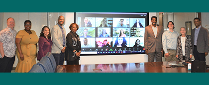 board members standing and on TV screen